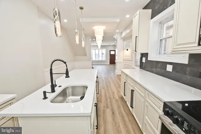 a kitchen with white cabinets and sink