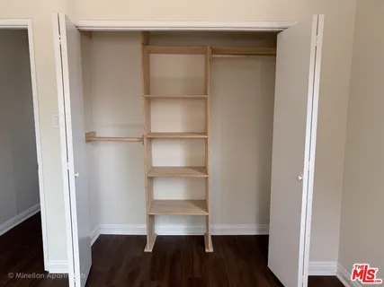 a view of walk in closet with empty racks