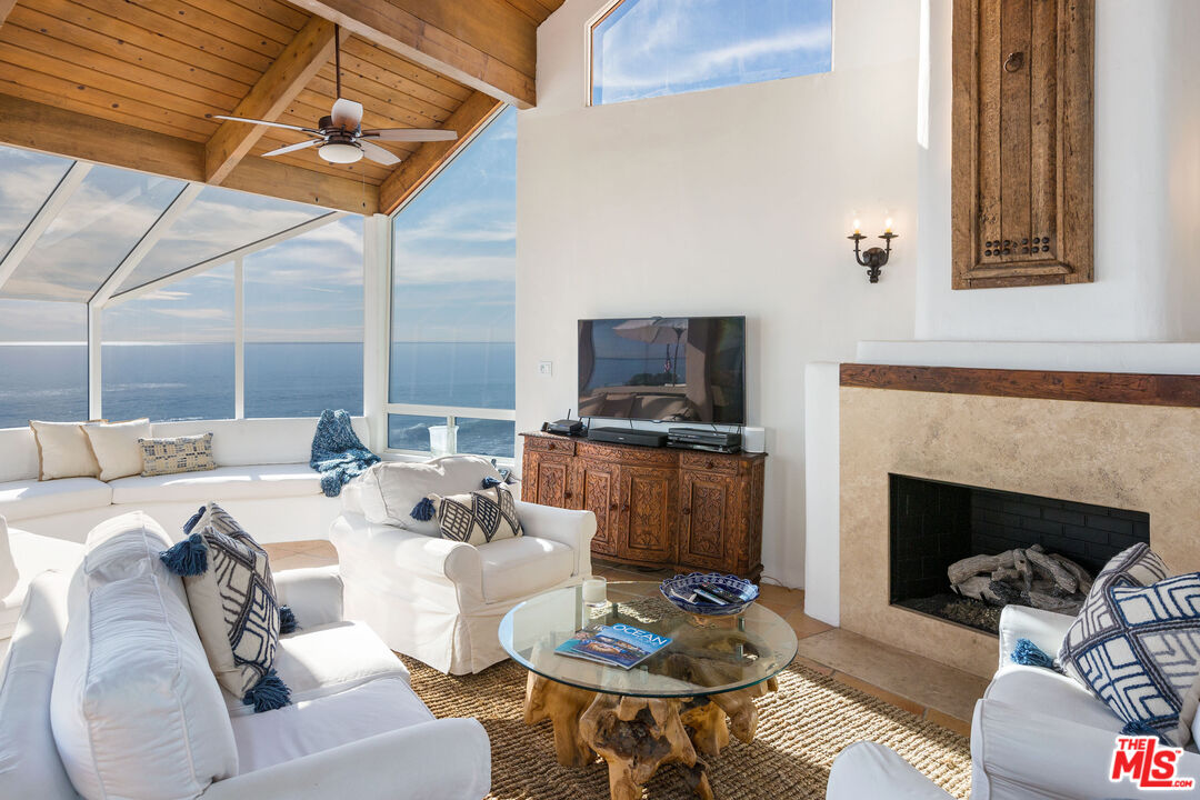 24408 Malibu Road Malibu, CA 90265 - Photo 11 of 44 a living room with furniture a fireplace and a flat screen tv