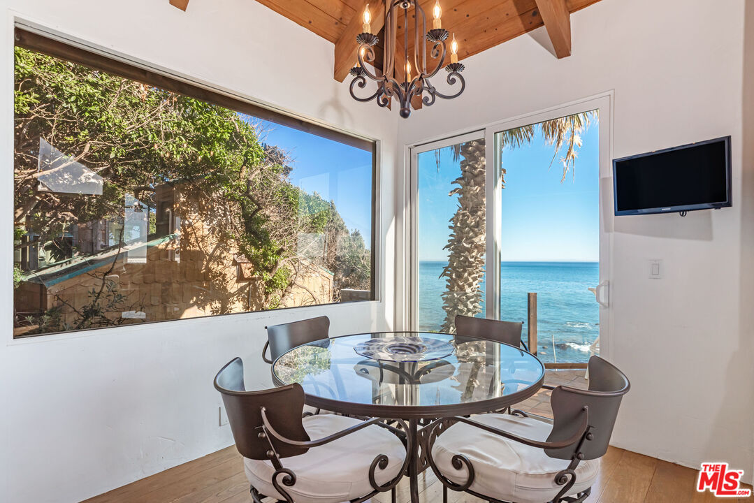 24408 Malibu Road Malibu, CA 90265 - Photo 14 of 39 a view of a dining room with furniture window and wooden floor