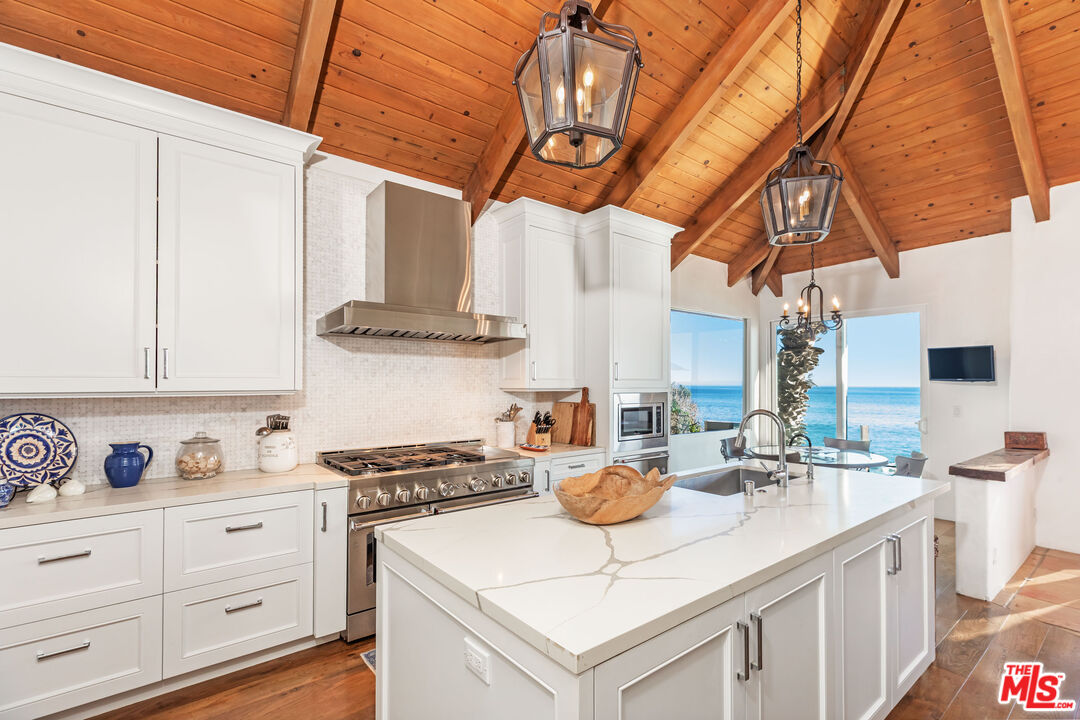 24408 Malibu Road Malibu, CA 90265 - Photo 15 of 39 a kitchen with stainless steel appliances granite countertop a sink a stove and cabinets