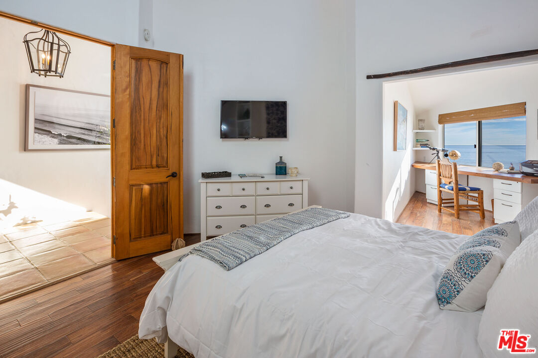 24408 Malibu Road Malibu, CA 90265 - Photo 19 of 44 a bedroom with a bed and flat tv screen on dresser
