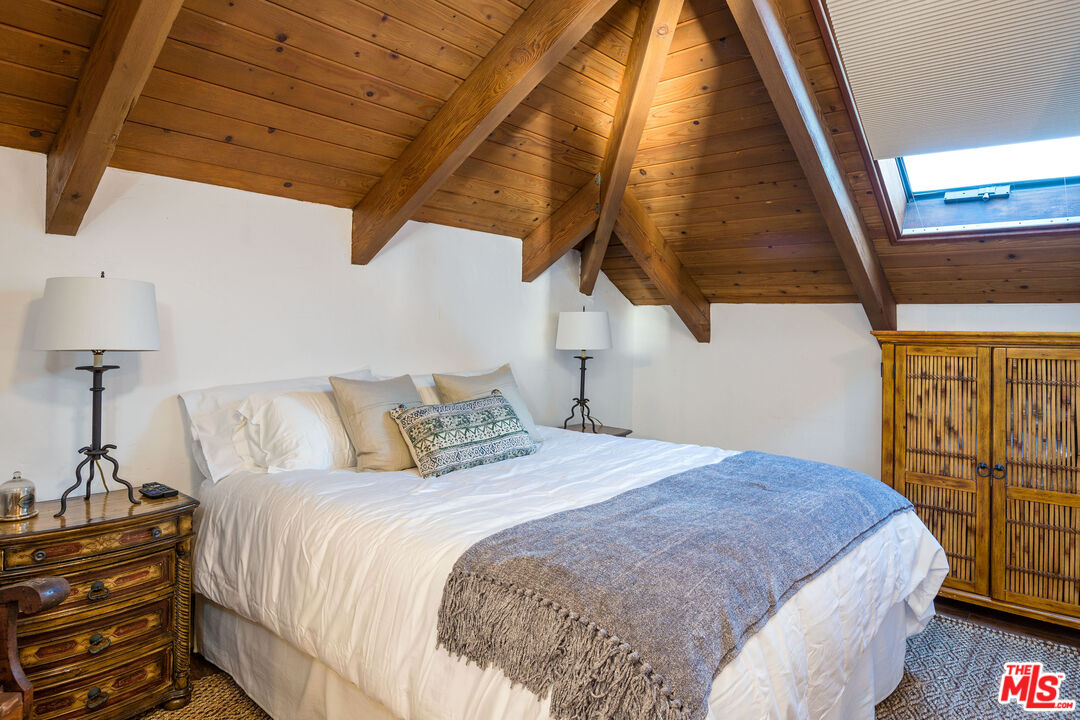 24408 Malibu Road Malibu, CA 90265 - Photo 22 of 44 a bedroom with a bed and a night stand