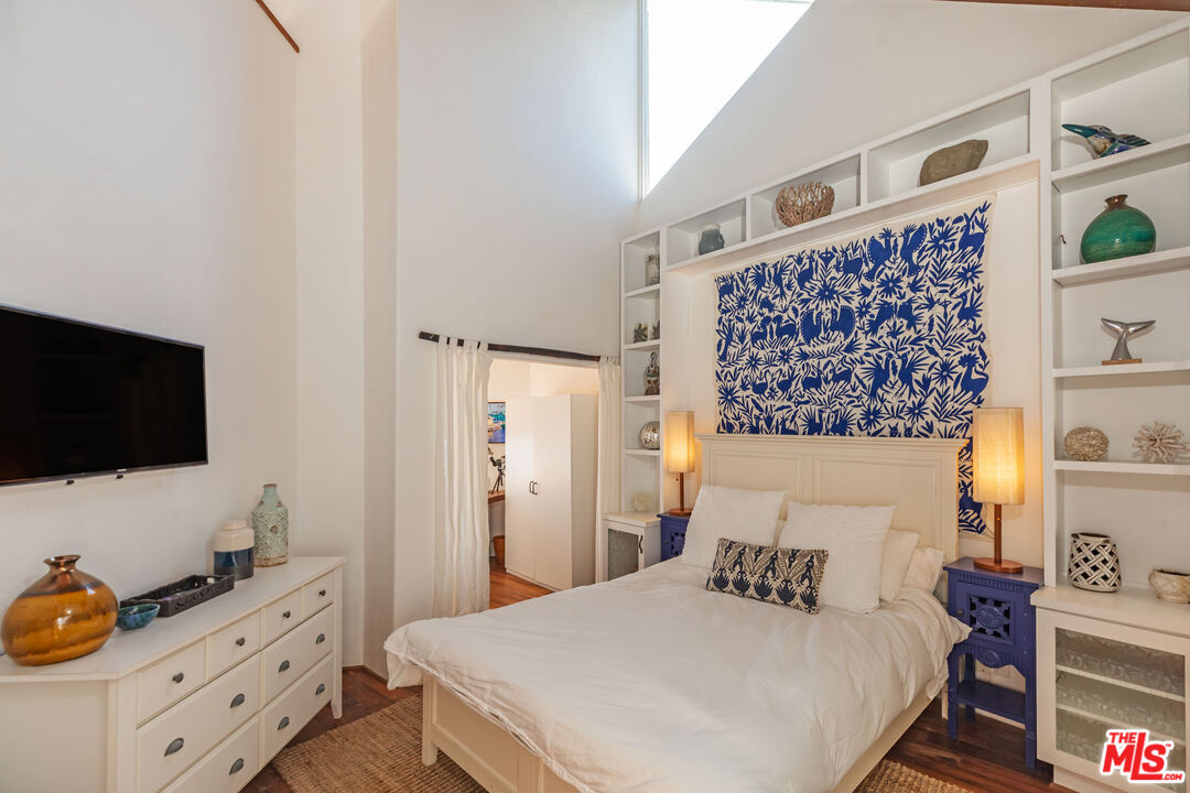 24408 Malibu Road Malibu, CA 90265 - Photo 26 of 39 a bedroom with a bed and flat screen tv