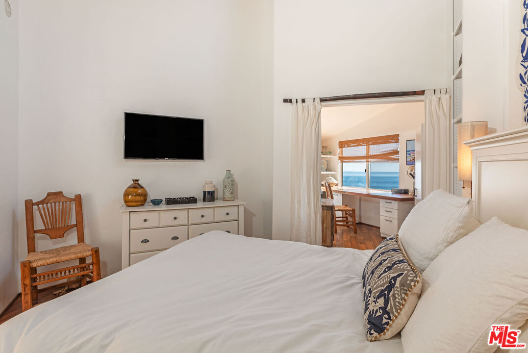 24408 Malibu Road Malibu, CA 90265 - Photo 28 of 39 a bedroom with a bed and a flat screen tv