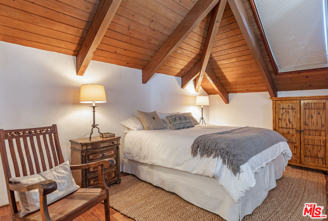 24408 Malibu Road Malibu, CA 90265 - Photo 29 of 39 a bedroom with a bed and wooden floor
