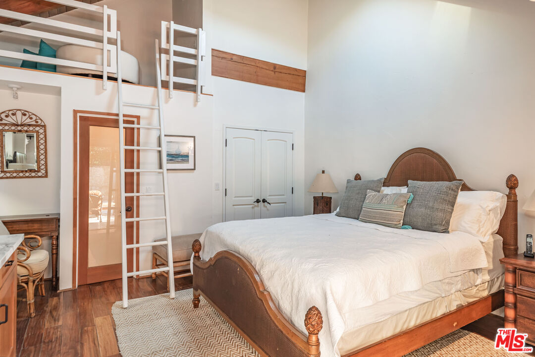 24408 Malibu Road Malibu, CA 90265 - Photo 30 of 39 a bedroom with a bed and wooden floor