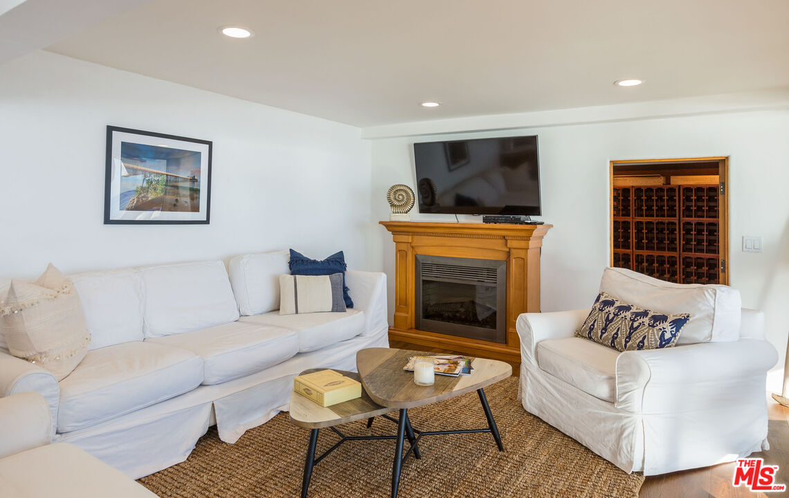 24408 Malibu Road Malibu, CA 90265 - Photo 38 of 44 a living room with furniture a flat screen tv and a fireplace
