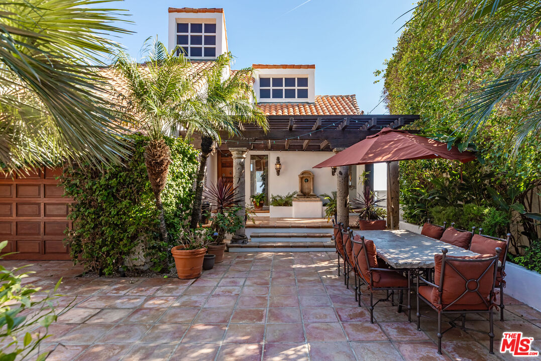 24408 Malibu Road Malibu, CA 90265 - Photo 4 of 39 a view of a patio with a table and chairs under an umbrella