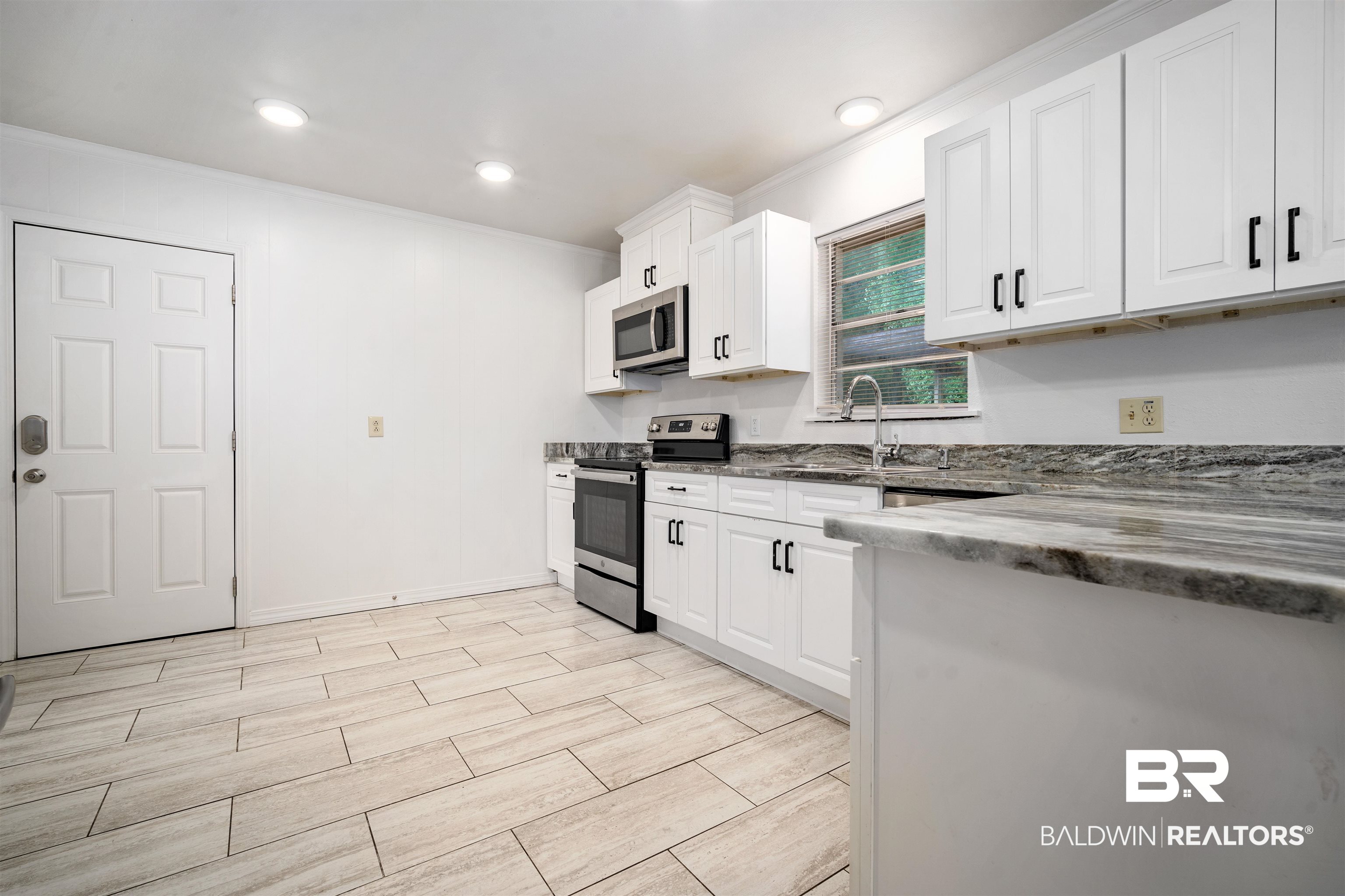 570 Markham Drive Mobile, AL 36609 - Photo 7 of 25 Kitchen with a sink, wood tiled floor, stainless steel appliances, white cabinetry, and ornamental molding