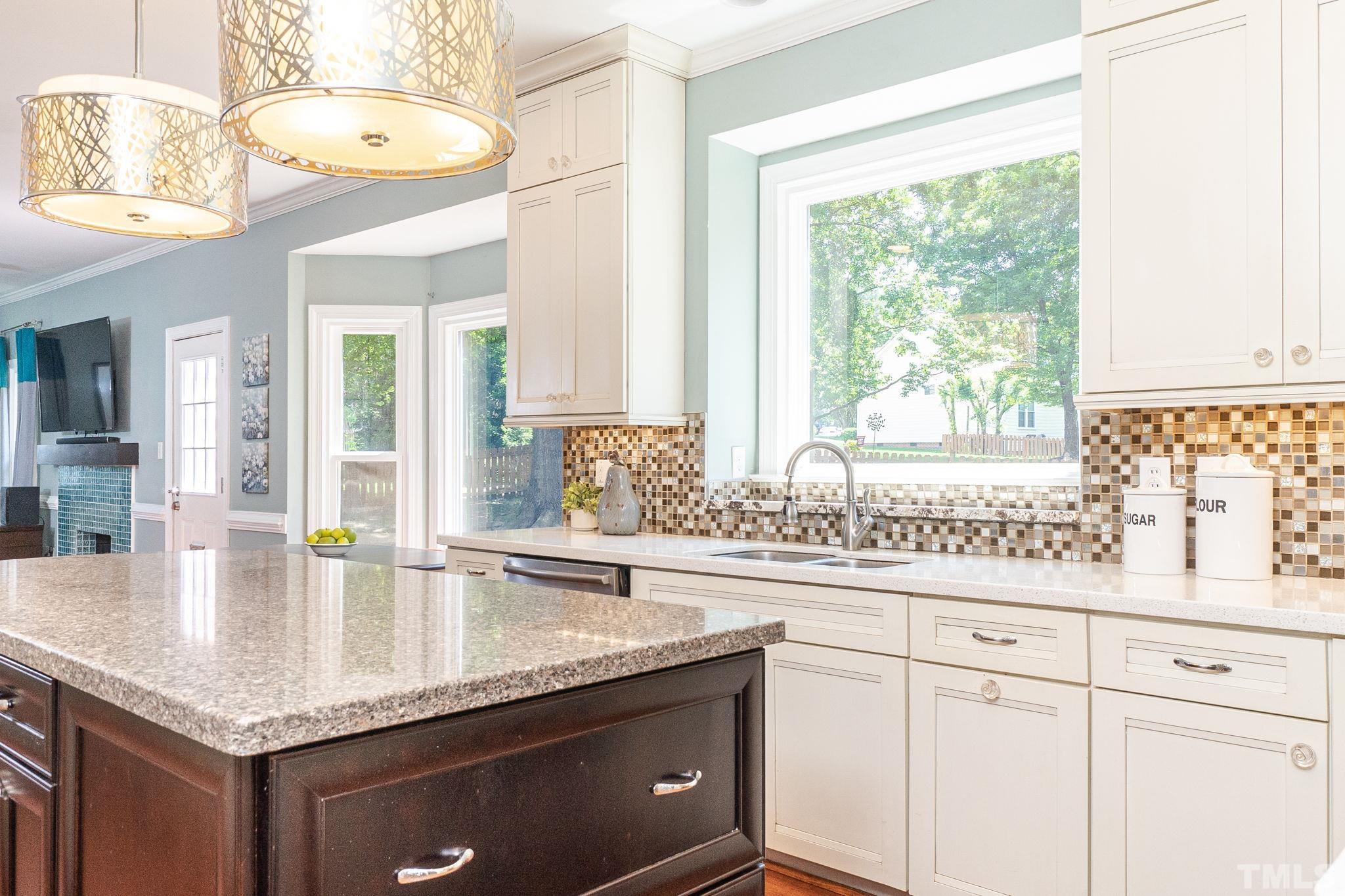 5717 Raddington Street Raleigh, NC 27613 - Photo 15 of 58 a kitchen with granite countertop a sink a stove and cabinets