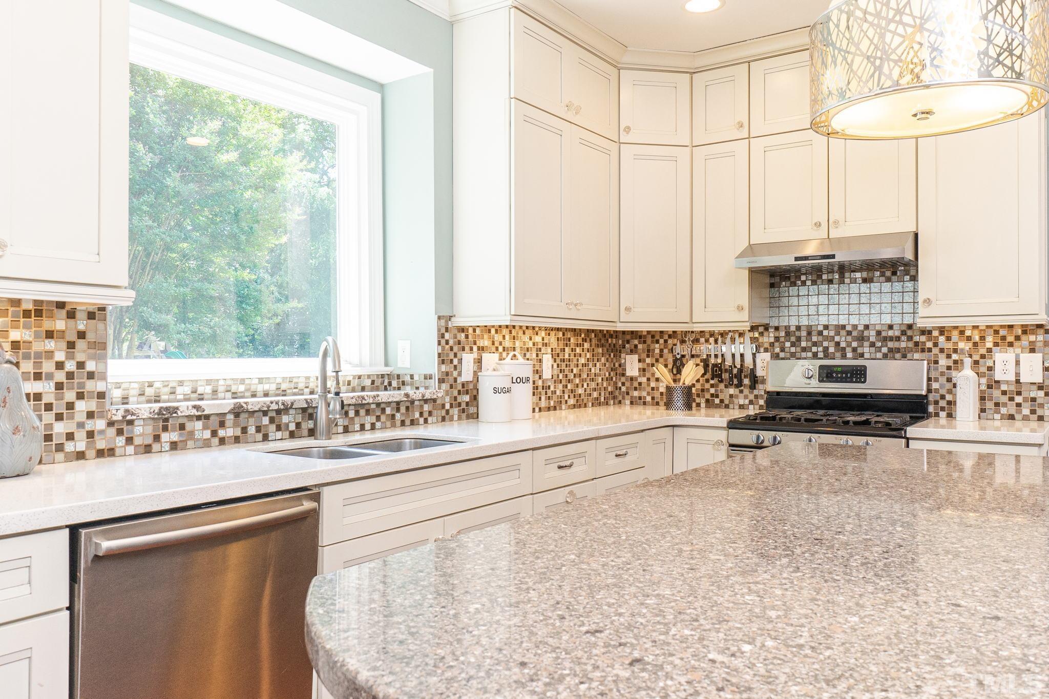 5717 Raddington Street Raleigh, NC 27613 - Photo 17 of 58 a kitchen with stainless steel appliances a sink and a stove