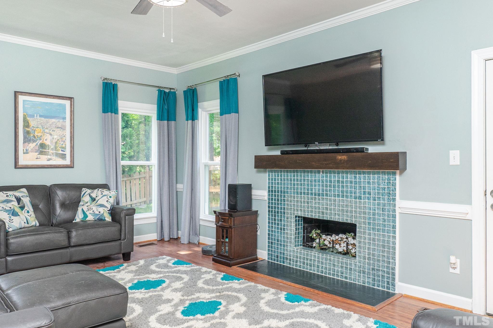 5717 Raddington Street Raleigh, NC 27613 - Photo 26 of 58 a living room with furniture a flat screen tv and a fireplace