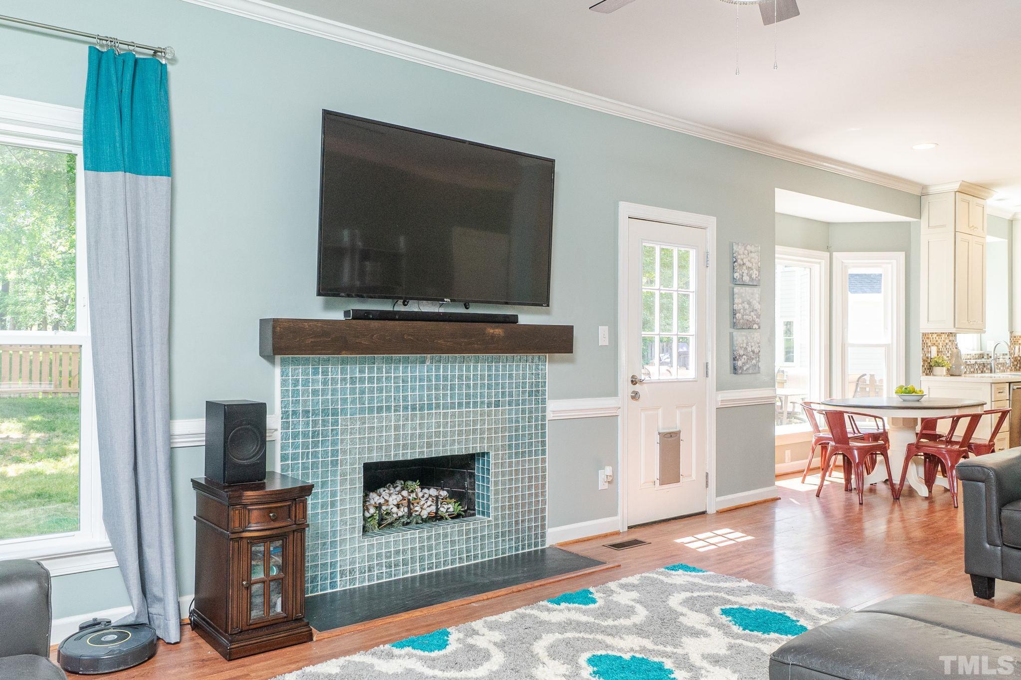 5717 Raddington Street Raleigh, NC 27613 - Photo 28 of 58 a living room with furniture a flat screen tv and a fireplace