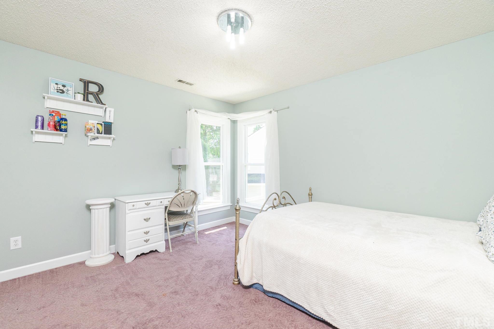 5717 Raddington Street Raleigh, NC 27613 - Photo 34 of 58 a spacious bedroom with a bed and a desk