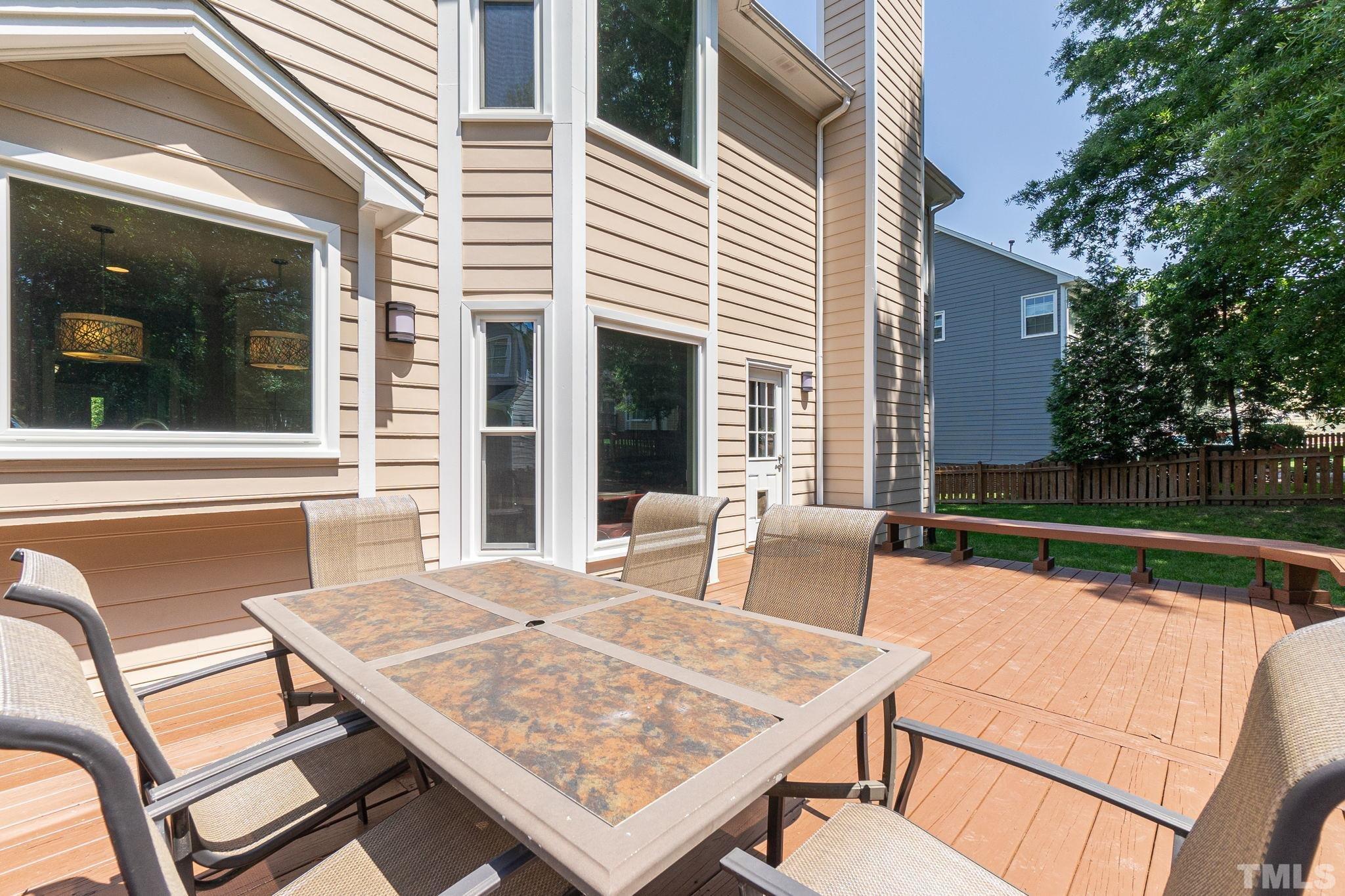 5717 Raddington Street Raleigh, NC 27613 - Photo 58 of 58 a view of a patio with table and chairs with wooden floor and fence