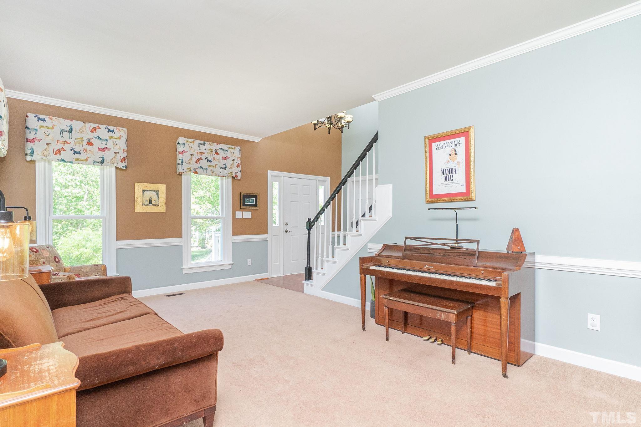 5717 Raddington Street Raleigh, NC 27613 - Photo 10 of 58 a living room with furniture a piano and a window