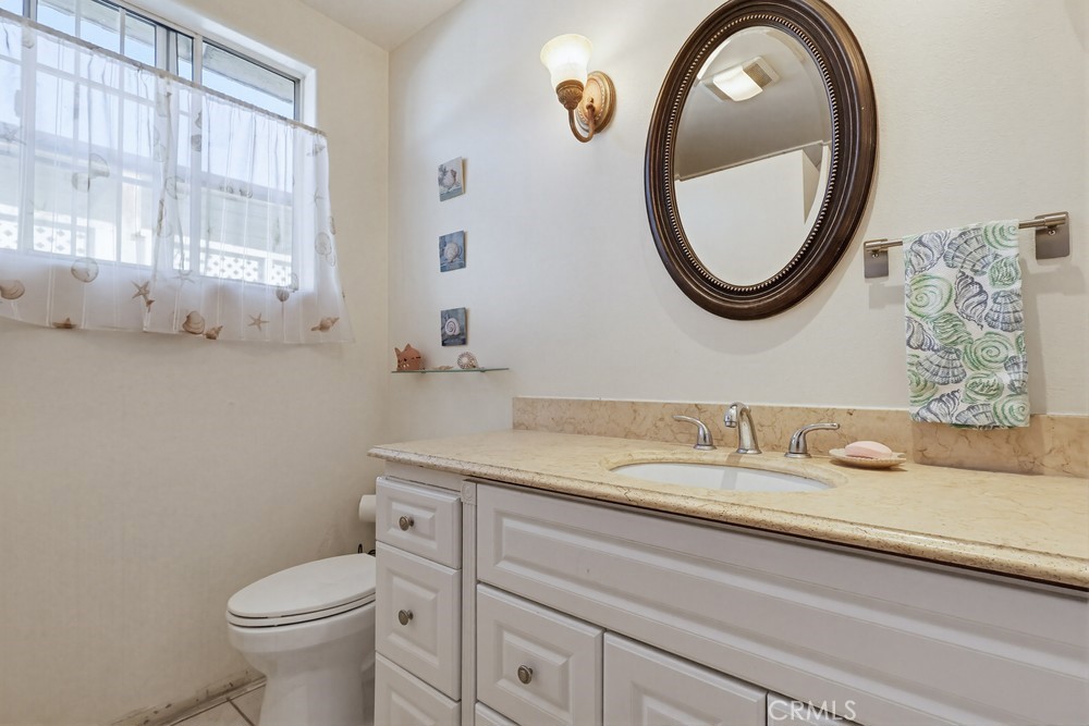 10970 Ruth Avenue Lynwood, CA 90262 - Photo 9 of 27 a bathroom with a granite countertop toilet sink and mirror