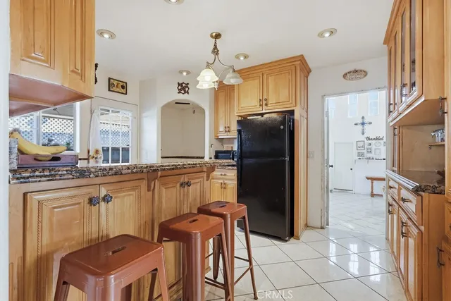 a kitchen with stainless steel appliances granite countertop a refrigerator a stove and a sink