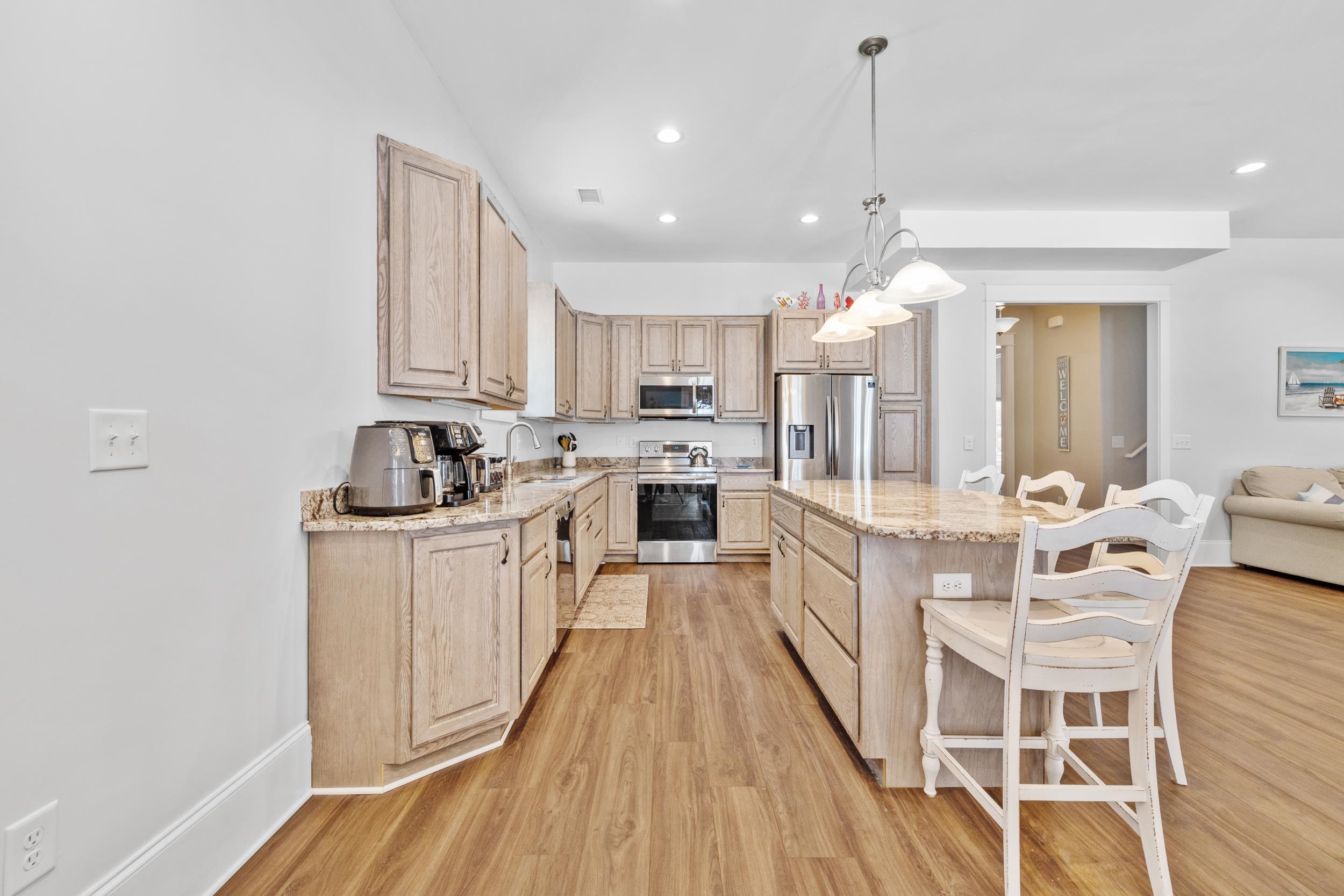 5907 Haskell Circle Myrtle Beach, SC 29577 - Photo 10 of 38 Kitchen with light brown cabinets, light stone countertops, hanging light fixtures, a breakfast bar, and recessed lighting