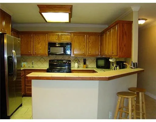 a kitchen with stainless steel appliances granite countertop a sink and a refrigerator