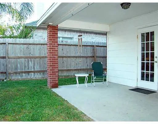 a view of a chair and table in backyard of the house