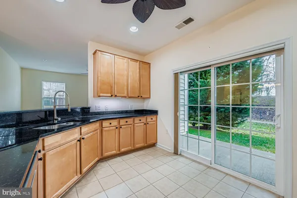 a kitchen with granite countertop a sink and white cabinets