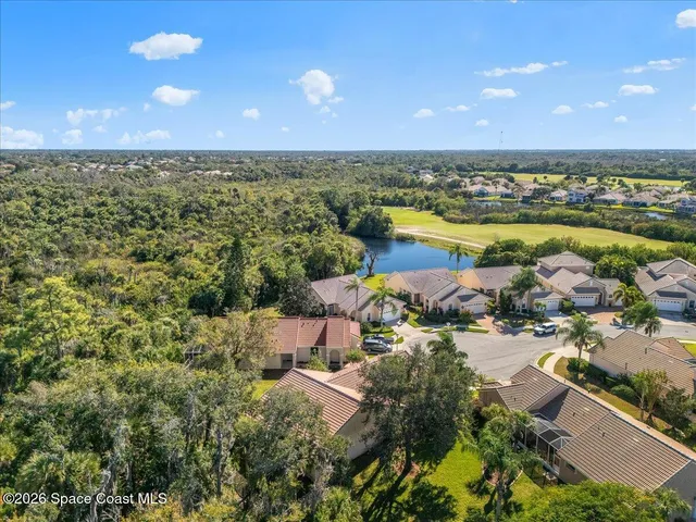 an aerial view of ocean and residential houses with outdoor space