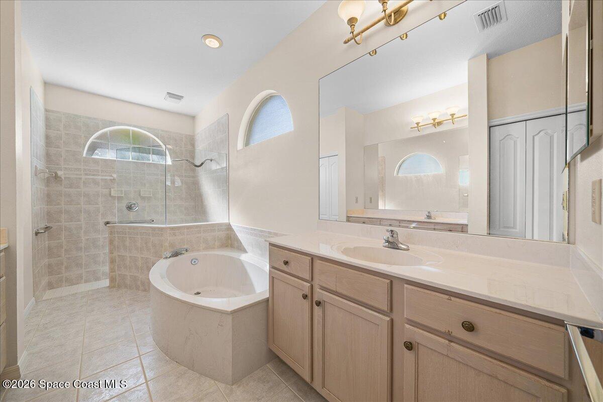 8200 Simpkins Way Melbourne, FL 32940 - Photo 37 of 49 a bathroom with a sink a large mirror and a bathtub