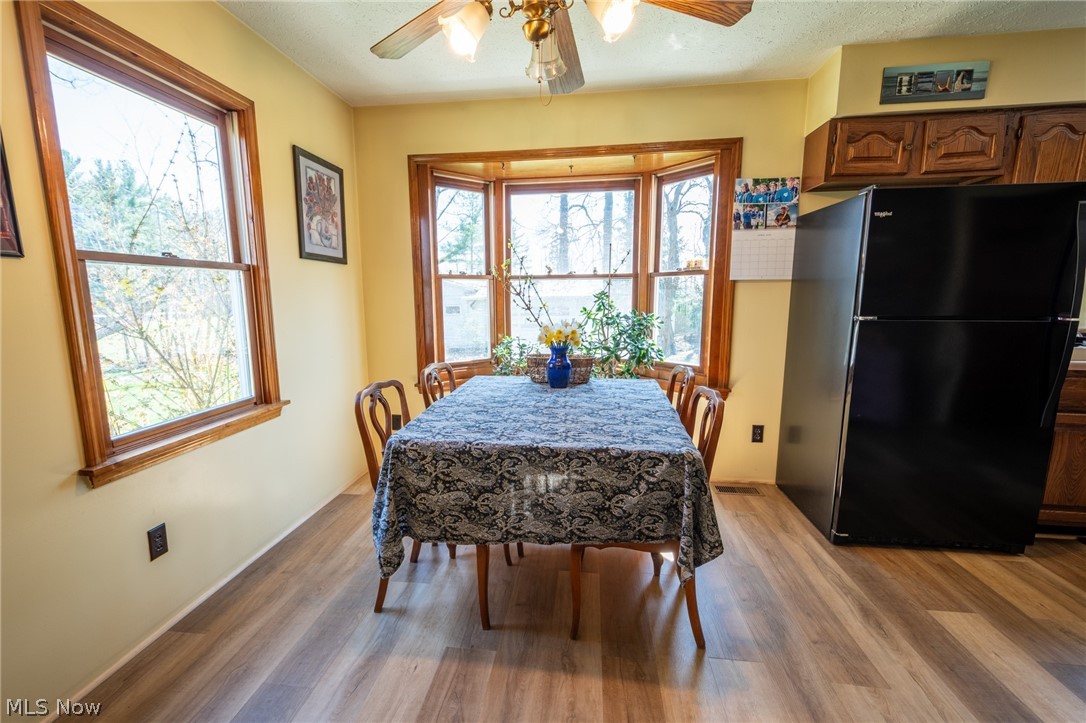 14027 Mayfield Road Huntsburg, OH 44046 - Photo 11 of 50 Dining area featuring a bay window, wood-finish flooring, and a ceiling fan
