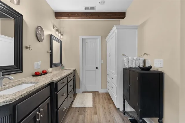 a bathroom with a granite countertop sink and a mirror