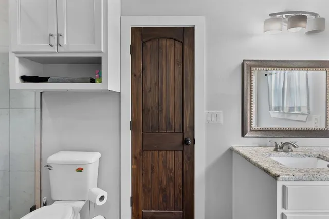 a bathroom with a sink a toilet and shower