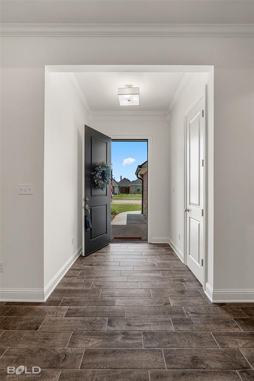 304 Prien Lk Loop Bossier City, LA 71111 - Photo 7 of 39 Entryway featuring wood-look tile flooring, crown molding, a square ceiling light fixture, and a solid-panel interior door