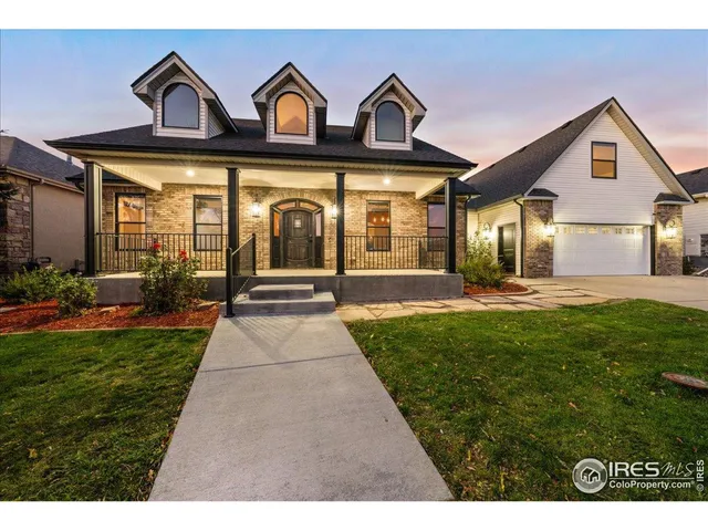 a view of a brick house with a yard garden and patio