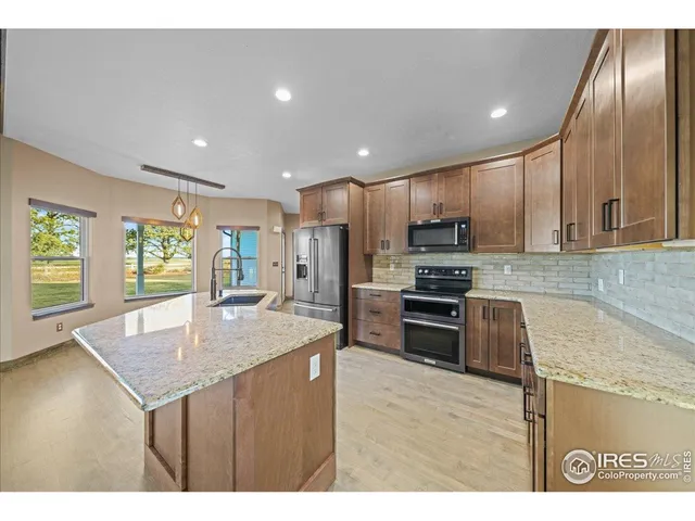 a kitchen with kitchen island granite countertop stainless steel appliances and sink