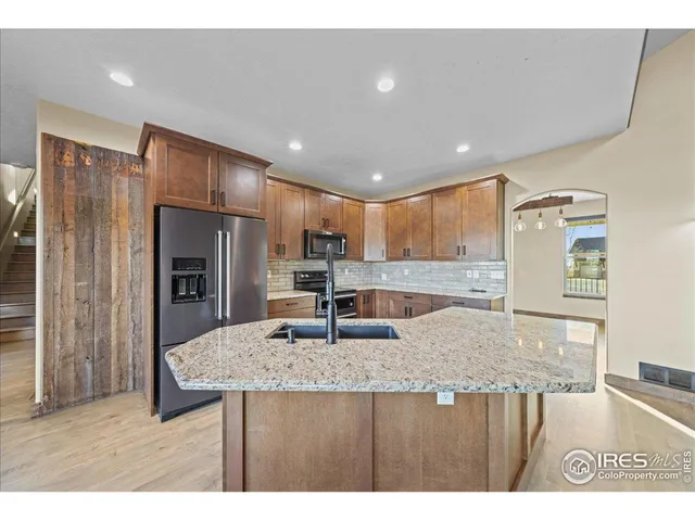 a kitchen with kitchen island a counter top space cabinets and stainless steel appliances