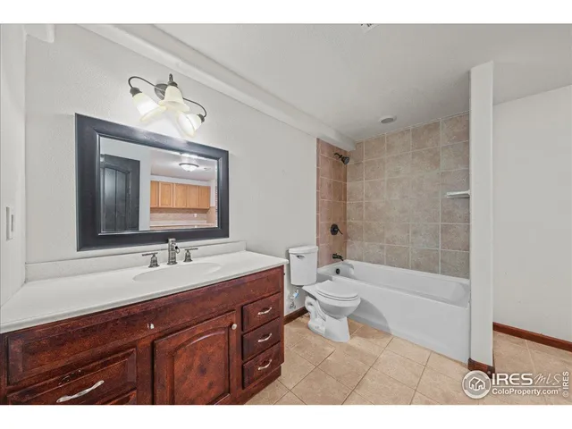 a bathroom with a sink a toilet a mirror and bathtub