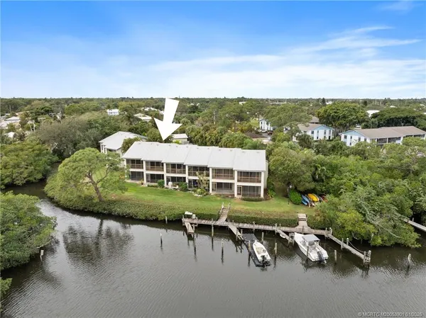 an aerial view of a house with a yard and lake view