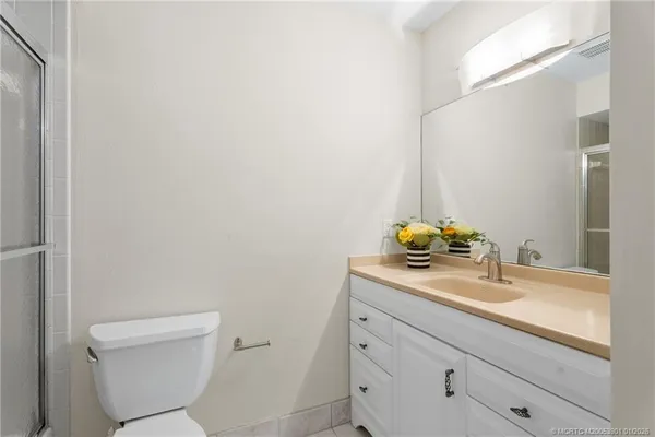 a bathroom with a granite countertop toilet sink and mirror