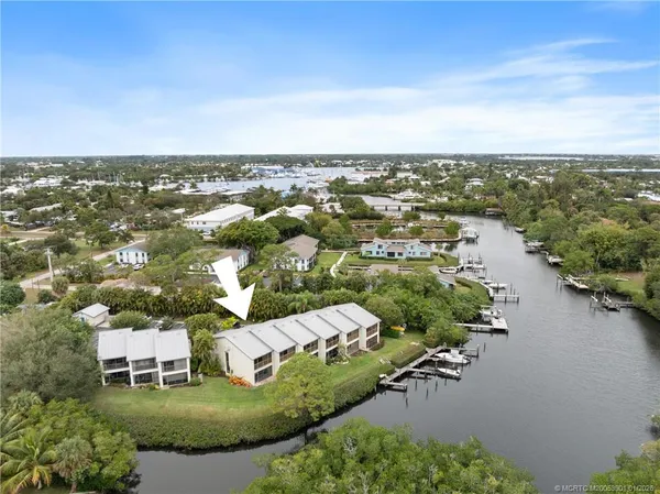 an aerial view of a house with a yard and lake view in back