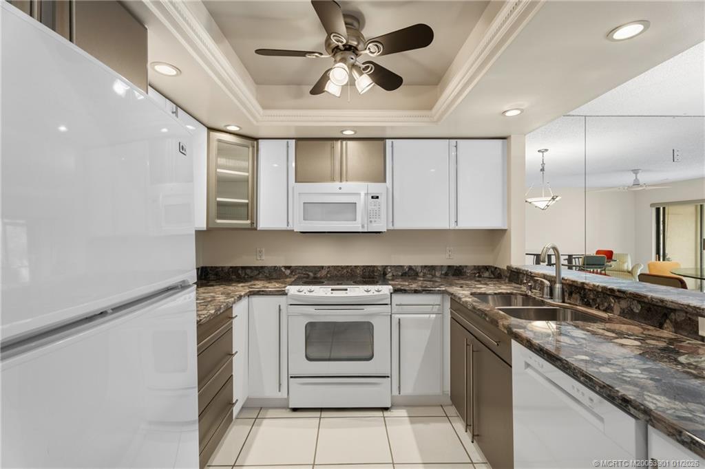4761 Southeast Binnacle Way, Unit 108 Stuart, FL 34997 - Photo 10 of 25 a kitchen with a stove sink and cabinets