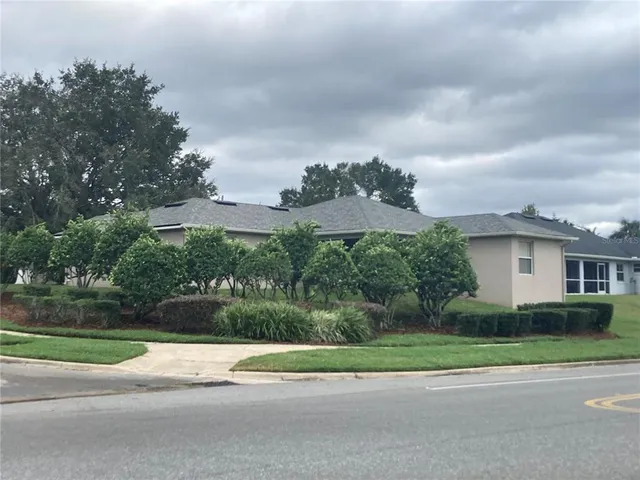 a view of a house with a yard and a large trees