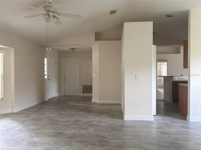an empty room with fan and entrance