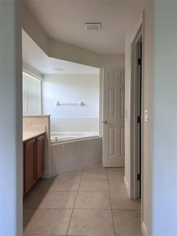 a bathroom with a bathtub and mirror