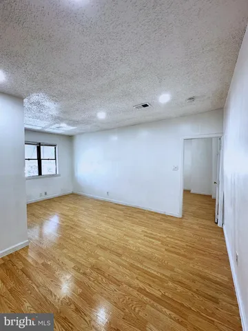 a view of empty room with wooden floor