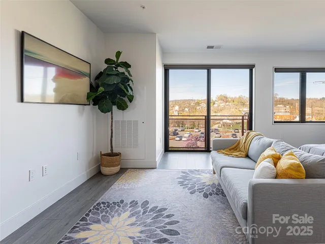 a living room with furniture and a floor to ceiling window