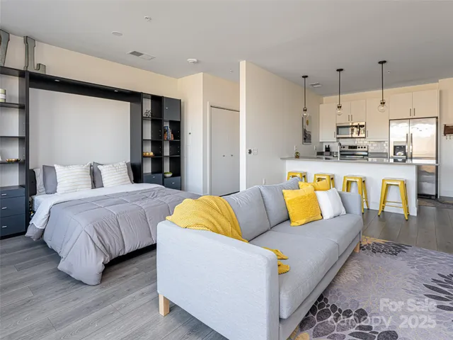 a large bedroom with a bed a table and a couch