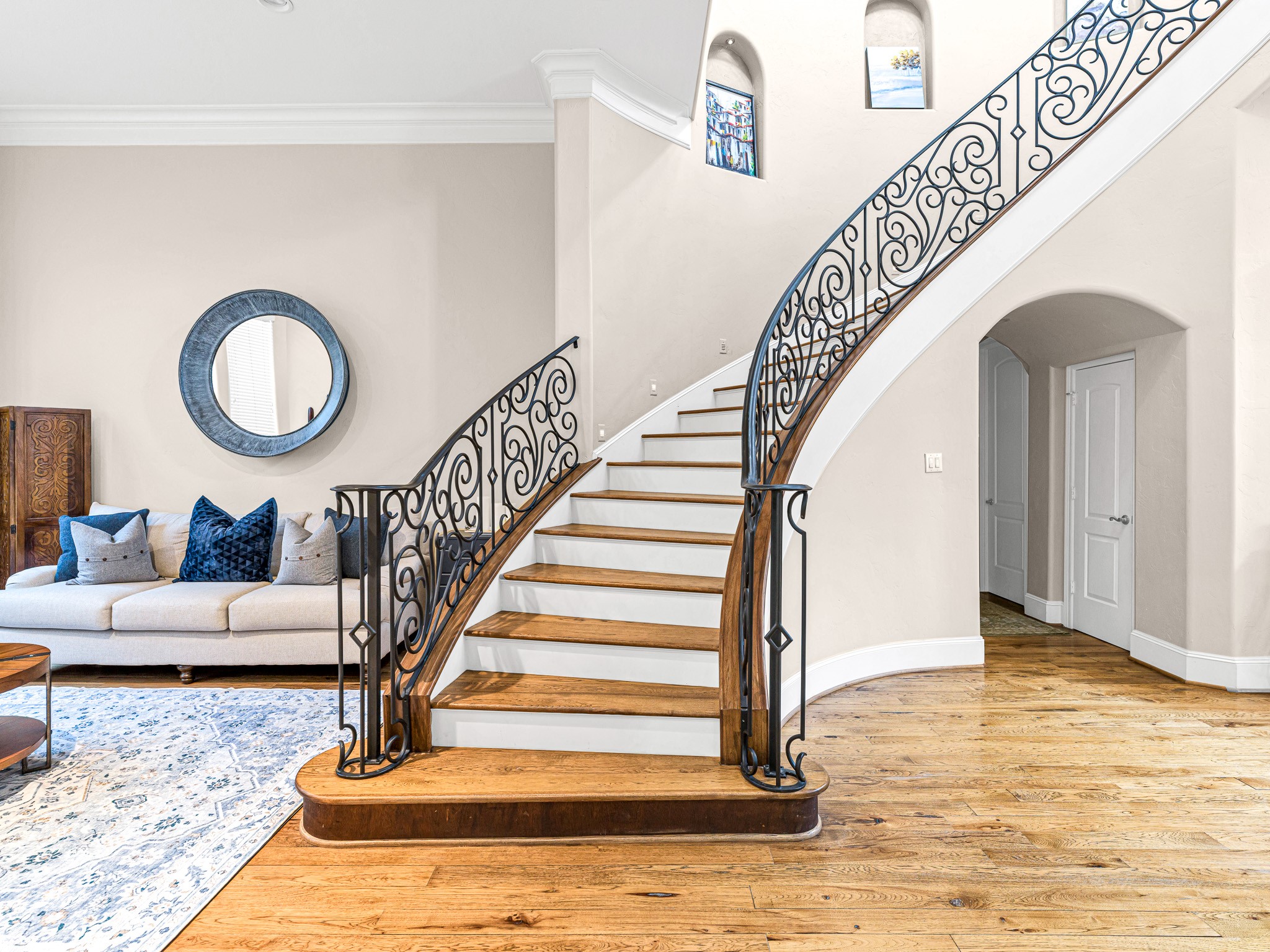4614 Inker Street Houston, TX 77007 - Photo 9 of 36 A bright living space with a grand, curved staircase featuring ornate wrought iron railings.