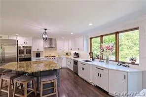 a view of living room kitchen with furniture and wooden floor