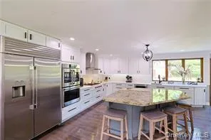 a kitchen with kitchen island granite countertop a sink stove and refrigerator